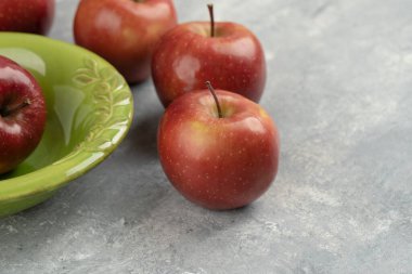 Taze kırmızı elmalar ve mermer arka planda boş kase. Yüksek kalite fotoğraf