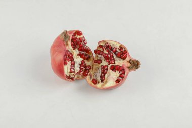 Dilimlenmiş taze olgun nar beyaz masaya konur. Yüksek kalite fotoğraf
