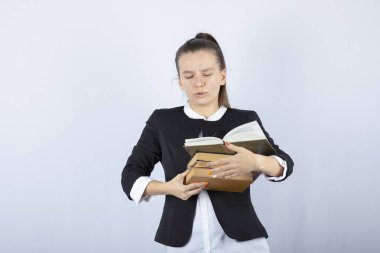 Beyaz arka planda duran kitapları olan genç bir kız öğrencinin portresi. Yüksek kalite fotoğraf