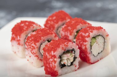 Beyaz Kaliforniya suşisi tabakası taştan arka planda yuvarlanıyor. Yüksek kalite fotoğraf