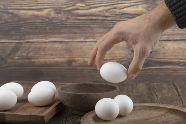 Mannelijke Hand Neemt Uit Kom Stapel Verse Eieren Houten Dienblad — Stockfoto