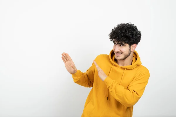 Foto Ung Brunett Man Gul Luvtröja Stående Och Poserande Högkvalitativt — Stockfoto