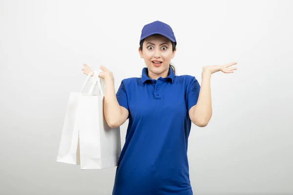 Hermosa Mensajera Femenina Traje Azul Sosteniendo Bolsas Blancas Foto Alta —  Fotos de Stock