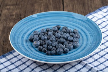 Ahşap zemin üzerinde mavi lezzetli taze yaban mersini tabağı. Yüksek kalite fotoğraf