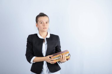 Kitapları beyaz arka planda duran genç ve güzel bir kız. Yüksek kalite fotoğraf