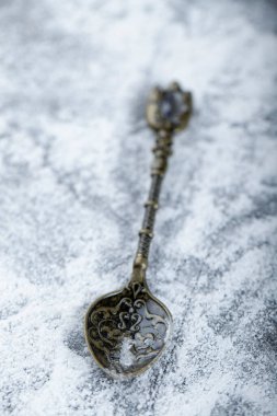Single metal spoon and spilled flour on dark surface. High quality photo