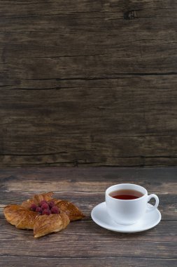 Ahşap masaya bir fincan siyah çay konmuş lezzetli ahududulu börek. Yüksek kalite fotoğraf