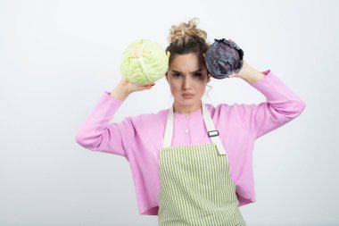 Önlüklü, lahanalı, sağlıklı yaşam tarzını destekleyen genç bir kadın. Yüksek kalite fotoğraf