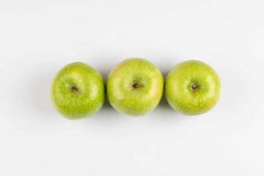 Three fresh green apples placed on white background. High quality photo