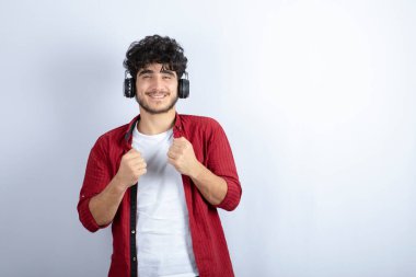 Kulaklıklı genç bir adamın beyaz arka planda dans edişi. Yüksek kalite fotoğraf