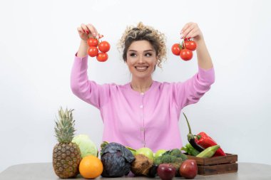 Meyve masasında oturan sarışın kırmızı domateslerin portresi. Yüksek kalite fotoğraf