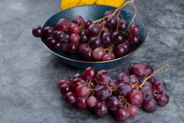 Mavi kase taştan arka planda sulu kırmızı üzümlerle dolu. Yüksek kalite fotoğraf