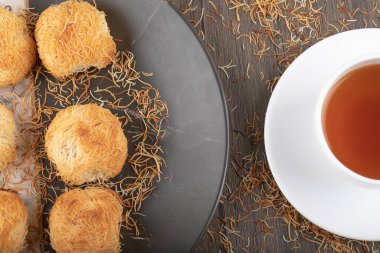 Tahta masaya beyaz bir fincan sıcak çay konmuş Türk tatlıları. Yüksek kalite fotoğraf