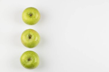 Three tasty green apples placed on white background. High quality photo