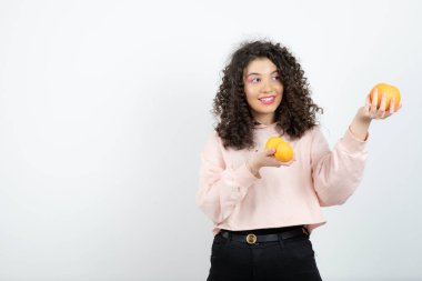 Güzel kıvırcık kız elinde taze portakal meyveleri tutuyor. Yüksek kalite fotoğraf