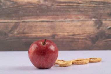 Beyaz masada kırmızı taze elma ve kurutulmuş elma halkaları. Yüksek kalite fotoğraf