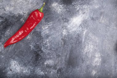 Single organic chili pepper placed on marble surface. High quality photo
