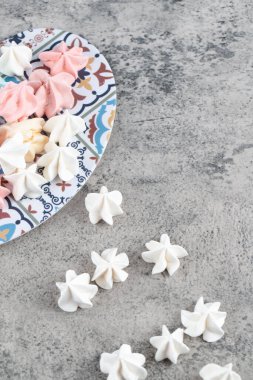 Taş zeminde renkli tatlı kremalı şekerler tabağı. Yüksek kalite fotoğraf