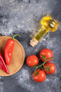 Kırmızı biber, olgun domates ve mermer yüzeyde bir şişe yağ. Yüksek kalite fotoğraf