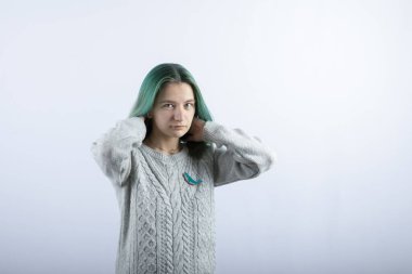 Beyaz arka planda kameraya poz veren yeşil saçlı kızın portresi. Yüksek kalite fotoğraf