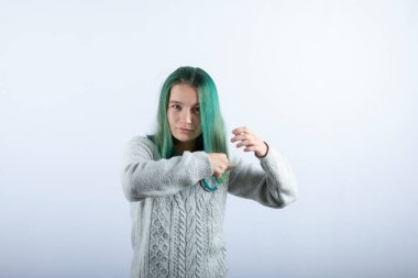 Saçlarını beyaz arka planda tarayan yeşil saçlı kızın portresi. Yüksek kalite fotoğraf