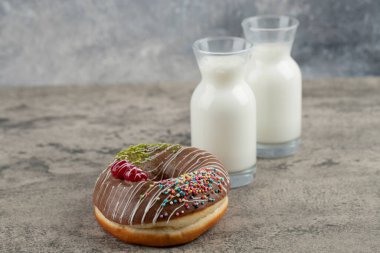 Çikolatalı çörek ve taş yüzeyde taze sütle süslenmiş. Yüksek kalite fotoğraf