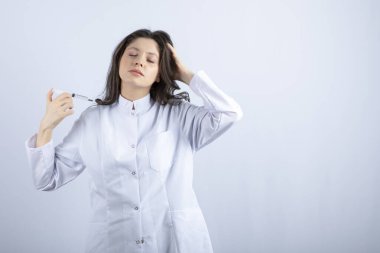 Beyaz arka planda uyuyan şırıngalı genç doktorun fotoğrafı. Yüksek kalite fotoğraf