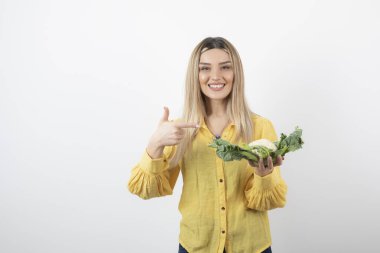 Karnabahar taşıyan güzel, gülümseyen bir kadın manken resmi. Yüksek kalite fotoğraf