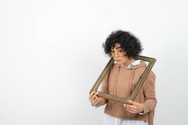 Beyazın üzerinde ahşap çerçeve etrafında oynayan komik güzel kadın. Yüksek kalite fotoğraf