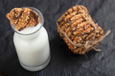 Siyah arka planda bir şişe sütle taze susamlı kurabiyeler. Yüksek kalite fotoğraf