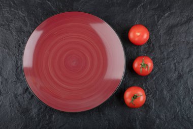 Siyah arka planda üç taze kırmızı domates tabağı. Yüksek kalite fotoğraf