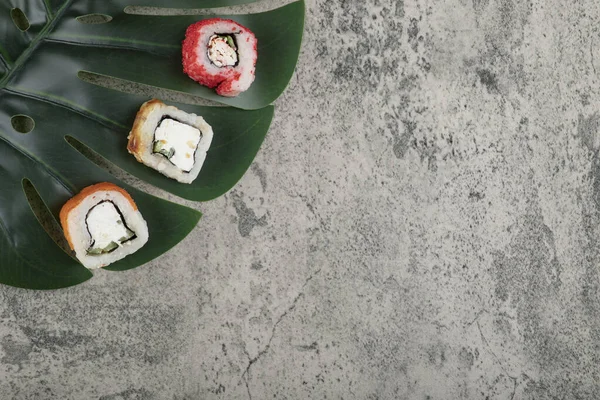 Különböző Finom Sushi Tekercsek Zöld Levél Felületen Kiváló Minőségű Fénykép — Stock Fotó