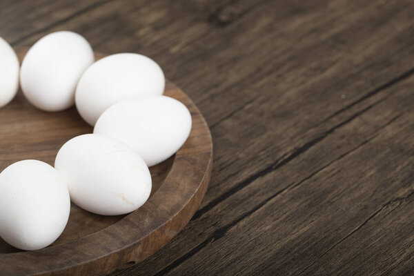 Close up photo of pile of fresh eggs on wooden tray. High quality photo