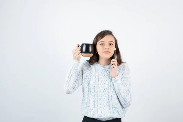 Młoda Kobieta Trzyma Filiżankę Gorącej Kawy Rozmawia Przez Telefon Wysokiej — Zdjęcie stockowe