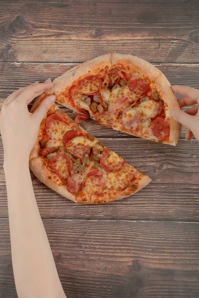 Weibliche Hand Nimmt Ein Stück Pfefferoni Pizza Auf Den Holztisch — Stockfoto