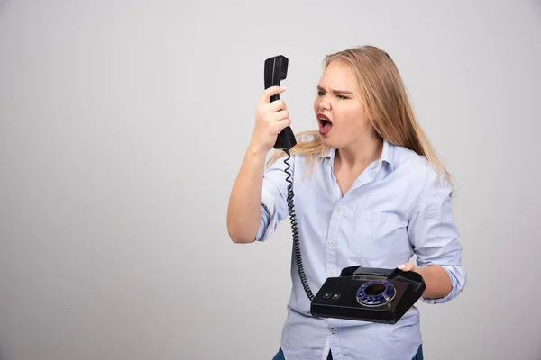 Photo Screaming Woman Holding Phone Talking Isolated Gray Background High — Stock Photo, Image