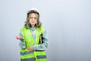 Not defteriyle beyaz duvarın ötesini düşünen güzel bir kadın mühendis resmi. Yüksek kalite fotoğraf