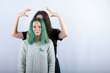 Genç bir kadın beyaz arka planda arkadaşıyla oynuyor. Yüksek kalite fotoğraf