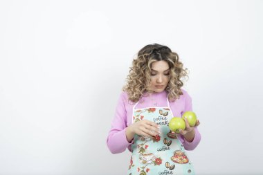 Elinde yeşil elmalar olan önlüklü genç ev kadınının portresi. Yüksek kalite fotoğraf