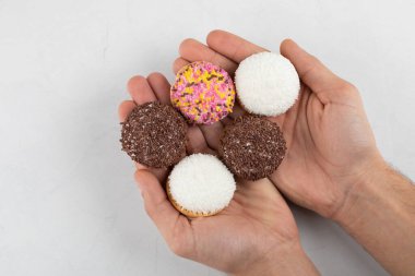 Beyaz arka planda renkli serpiştirilmiş taze kurabiyeler tutan erkek eller. Yüksek kalite fotoğraf