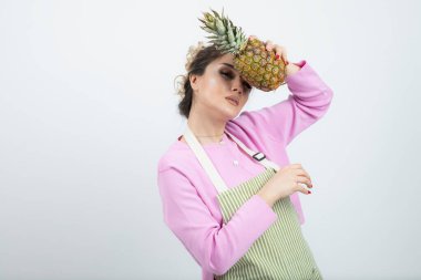 Elinde olgun tropik ananas tutan önlüklü güzel bir kadın. Yüksek kalite fotoğraf