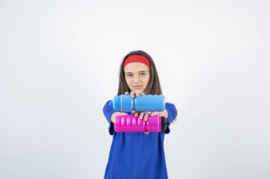 Renkli su şişeleri tutan genç bir kızın fotoğrafı. Yüksek kalite fotoğraf