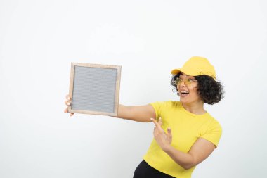 Beyaz arka planda poz veren pankartlı genç kadın. 