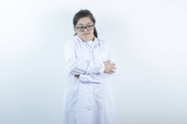 Doktor üniformalı genç bir kız kollarını kavuşturmuş duruyor. Yüksek kalite fotoğraf