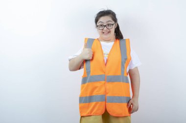 Gözlüklü genç bayan mühendis beyaz arka plan için onay veriyor. Yüksek kalite fotoğraf