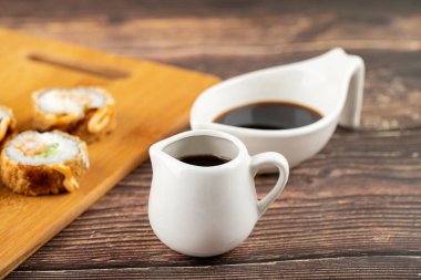 Ahşap masaya soya soslu taze suşi ruloları. Yüksek kalite fotoğraf