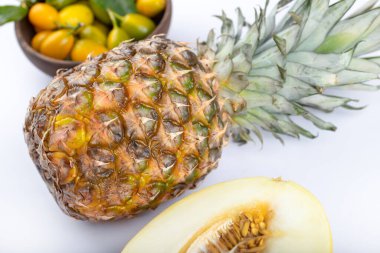 Beyaz arka planda bir kase kumkat, ananas ve kavun. Yüksek kalite fotoğraf