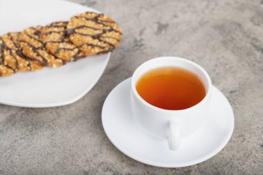 Beyaz tabak yulaflı çikolatalı bisküvi ve bir fincan çay. Yüksek kalite fotoğraf