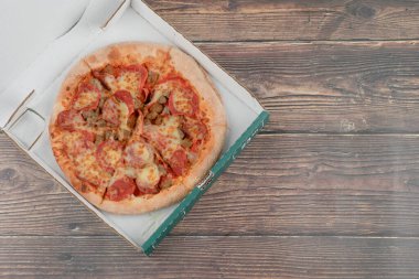 Karton kutuda salam ve etle karışık lezzetli pizza. Yüksek kalite fotoğraf