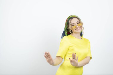 Mendilli, ayakta duran ve gözlüklü güzel bir kadının fotoğrafı. Yüksek kalite fotoğraf